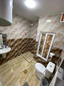 a bathroom with a toilet and a sink at Petra Main Gate Studios in Wadi Musa