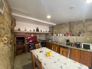 a kitchen with a table and a stone wall at Casa dos Telhados 