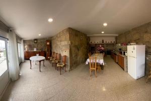 a kitchen with a refrigerator and a table and chairs at Casa dos Telhados 