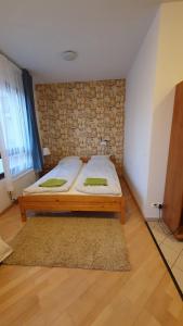 a bed in a room with a brick wall at Princess and Prince Apartman in Budapest