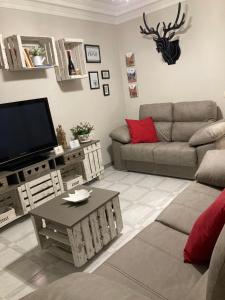 a living room with a couch and a tv at Casa Planta Baja.VTLR1431 in Rincón de Soto