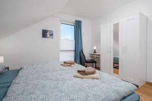 a bedroom with a bed with two towels on it at Am Thie in Hoisdorf