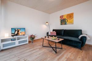 een woonkamer met een groene bank en een tafel bij Am Thie in Hoisdorf