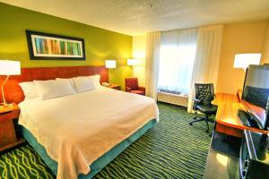 Habitación de hotel con cama, escritorio y TV. en Fairfield Inn Boise Airport, en Boise