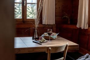 uma mesa com um prato de comida e um copo de vinho em Chalet Laugenblick em Santa Valpurga