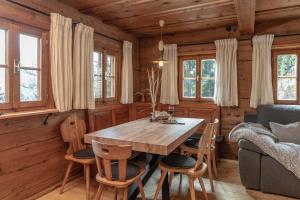 uma sala de jantar com uma mesa de madeira e cadeiras em Chalet Laugenblick em Santa Valpurga