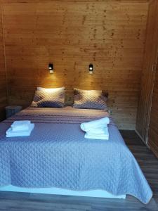 1 dormitorio con 1 cama con pared de madera en Quinta Do Fijo, en Arcos de Valdevez