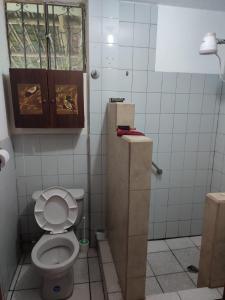 a small bathroom with a toilet and a cabinet at Casa galería de arte in Quito