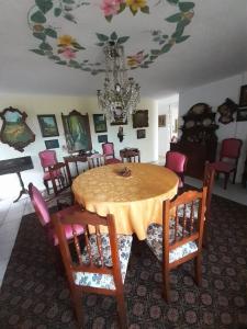 a dining room with a table and chairs and a chandelier at Casa galería de arte in Quito