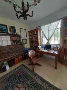 a room with a desk and a chair and a computer at Casa galería de arte in Quito