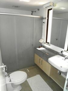 bagno con servizi igienici, lavandino e specchio di Cumbuco Ocean View a Cumbuco