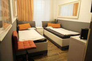 mały pokój z 2 łóżkami i krzesłem w obiekcie City Guesthouse Pension Berlin w Berlinie