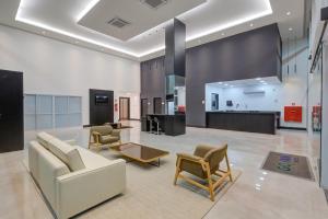 a living room with a white couch and chairs at Go Inn São Mateus in São Mateus