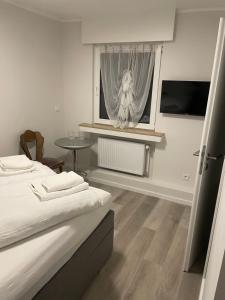 ein Schlafzimmer mit einem Bett und einem Fenster mit einem Vorhang in der Unterkunft Glessener Braustube in Bergheim