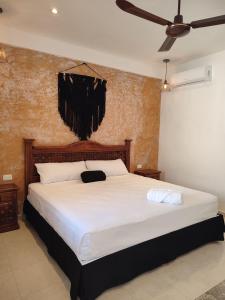 a bedroom with a large white bed with a ceiling fan at Hotel Casa Henequén in Valladolid