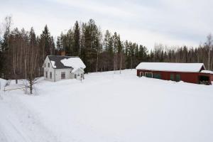 una casa en la nieve frente a un bosque en Rustic home surrounded by forest in Skellefteå, en Skellefteå