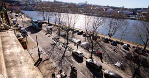 a city street with cars parked next to a river at Casa do Recanto in Porto