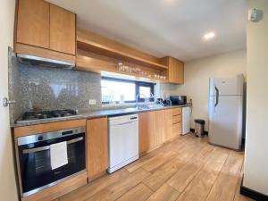 a kitchen with wooden cabinets and a white refrigerator at Dpto de Categoría en Arelauquen Golf & Country in San Carlos de Bariloche