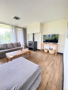 sala de estar con cama y sofá en Dpto de Categoría en Arelauquen Golf & Country en San Carlos de Bariloche
