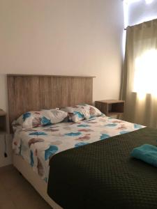 um quarto com uma cama com um edredão e almofadas em Vista Andes VII em Luján de Cuyo