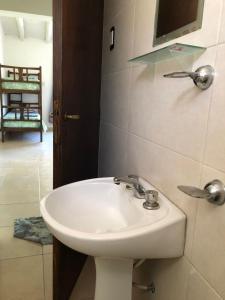baño con lavabo y TV en la pared en Vista Andes VII en Luján de Cuyo