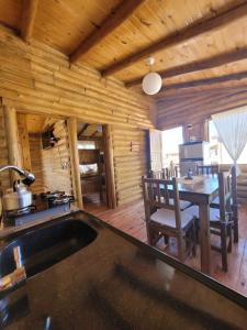 a kitchen and dining room in a log cabin at Paramitas - cabañas y hostel de montaña in Uspallata