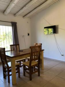 uma sala de jantar com uma mesa de madeira e cadeiras em Vista Andes VII em Luján de Cuyo