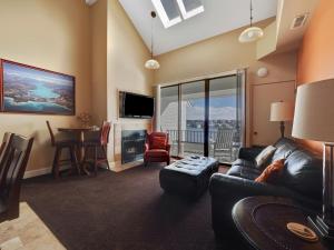 a living room with a couch and a table and a tv at 358 Edgewater Inn in Charlevoix