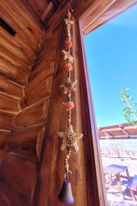 a bell on the side of a wooden wall at Paramitas - cabañas y hostel de montaña in Uspallata