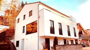 Casa blanca con ventanas con persianas negras en Starnberger See, en Feldafing