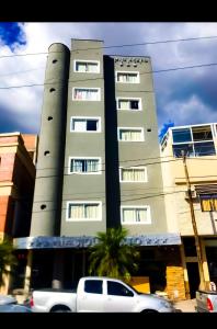 un camión blanco estacionado frente a un edificio alto en Hotel Siglo Sexto en Termas de Río Hondo