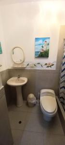 La salle de bains est pourvue de toilettes blanches et d'un lavabo. dans l'établissement Bellos Dptos Huanchaco, Perú a 50 metros del mar, à Trujillo