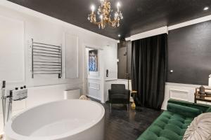 a bathroom with a large tub and a green couch at Couples Retreat With Jacuzzi Tub in Vancouver