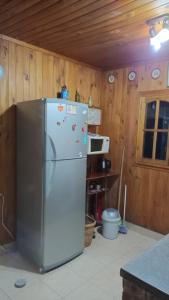 a refrigerator in a kitchen with wooden walls at Cabaña Uspallata, Mendoza. Para 4 personas in Uspallata