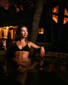 a woman in a bikini holding a glass of wine at Hotel y Cabañas Borde Andino in Las Trancas