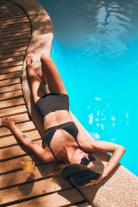 una donna sdraiata sul bordo di una piscina di Hotel y Cabañas Borde Andino a Las Trancas