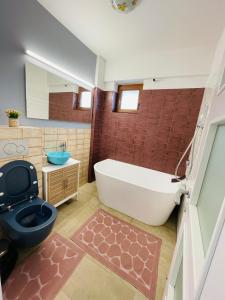 uma casa de banho com uma banheira, um WC e um lavatório. em Olive Apartament em Iaşi