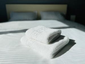 a stack of towels sitting on top of a bed at Olive Apartament in Iaşi