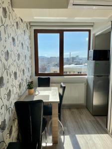 een keuken met een tafel en stoelen en een raam bij Olive Apartament in Iaşi