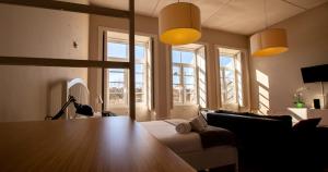 a living room with a table and some windows at Casa do Recanto in Porto