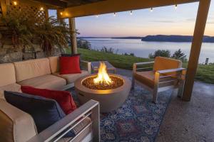 eine Feuerstelle auf einer Terrasse mit Blick auf das Wasser in der Unterkunft 180º Puget Sound View in Fox Island