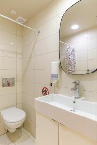 een badkamer met een toilet, een wastafel en een spiegel bij Sea Stars Apartment 1 in Perea +16 foto's