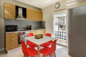 une cuisine avec une table et des chaises rouges dans l'établissement Sea Stars Apartment 1, à Peraia