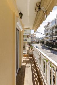 d'un balcon avec des chaises et des tables dans une rue. dans l'établissement Sea Stars Apartment 1, à Peraia