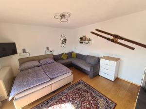 een slaapkamer met een bed en een bank bij Alpen Apartment The View in Bad Hofgastein