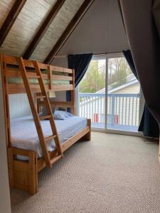 ein Schlafzimmer mit einem Etagenbett und einem großen Fenster in der Unterkunft Cottage by the bay, sleeps 8 near Rehoboth beach in Lewes