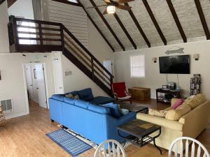 a living room with a blue couch and a tv at Cottage by the bay, sleeps 8 near Rehoboth beach in Lewes