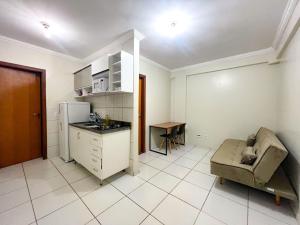 a kitchen with a couch and a table and a refrigerator at Apartamentos em Vicente Pires in Brasília