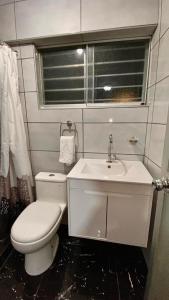 uma casa de banho com um WC branco e um lavatório. em Departamento completo Chanchamayo em La Merced
