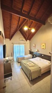 1 dormitorio grande con 2 camas y mesa en Apart Hotel Piscu Yaco en Merlo